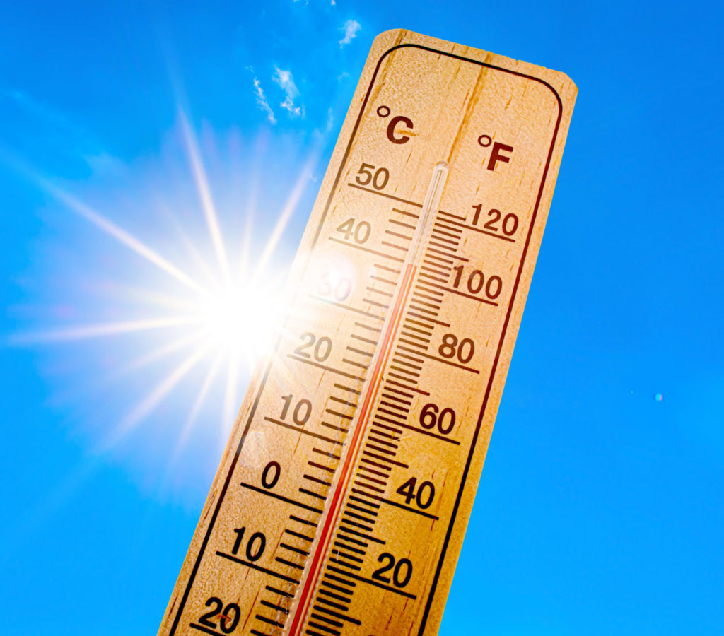 Summer background - blue sky with bright sun and thermometer