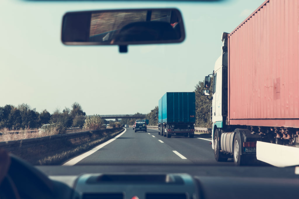 Person Driving on Road Beside Trailer Trucks (1)