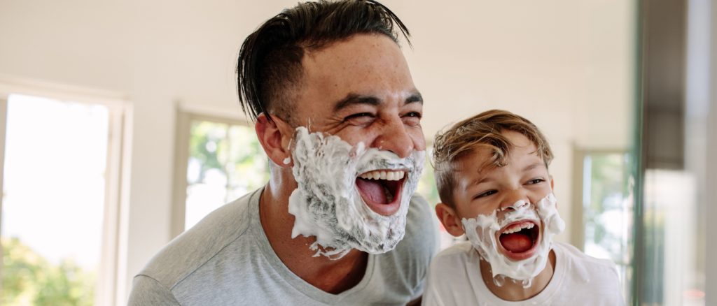 Father and son having fun while shaving in bathroom