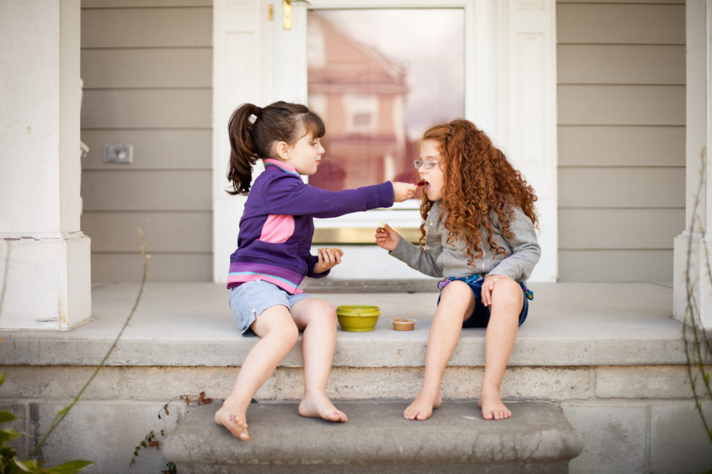 Little Girl Sharing a Snack with Her Sister