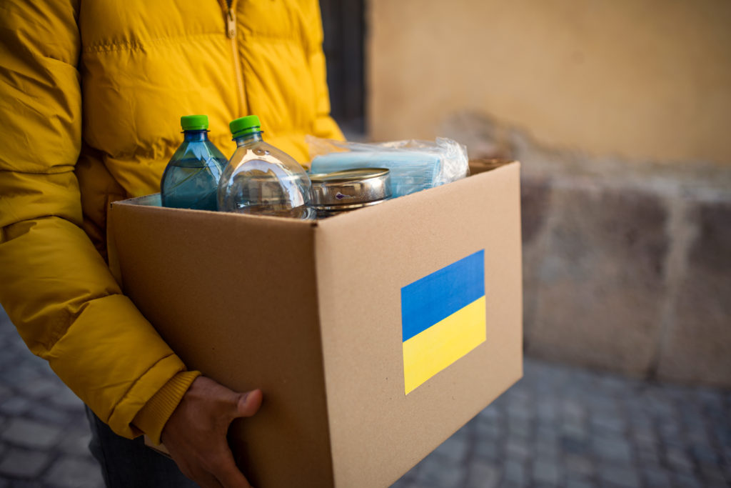 Close up of volunteer cyrrying box with Humanitarian aid for Ukrainian refugees in street