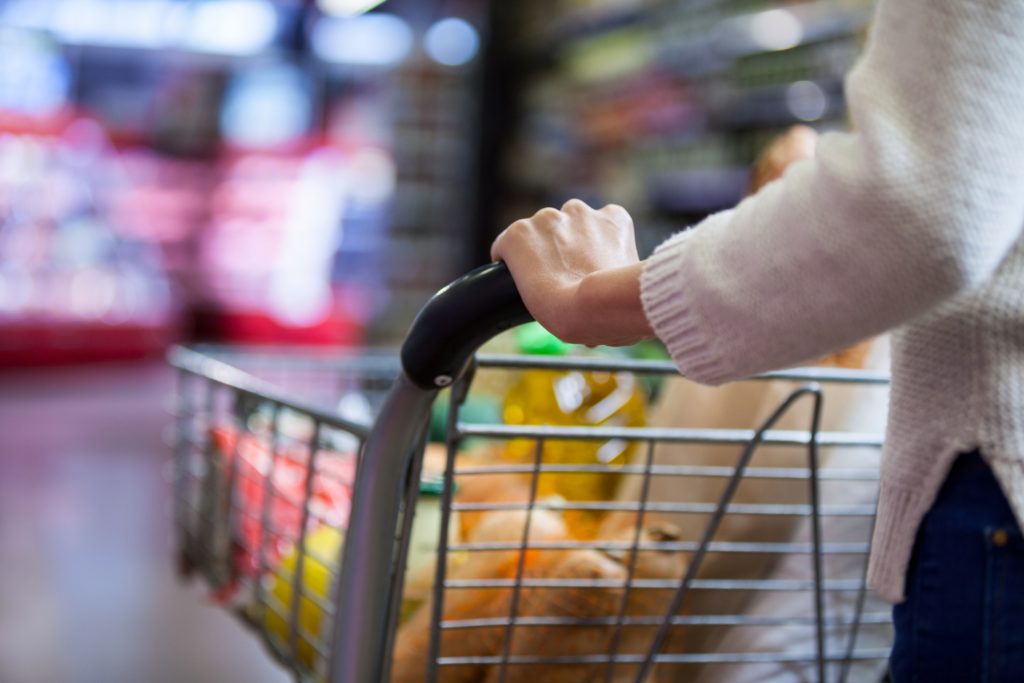 Woman holding groceries in shopping cart