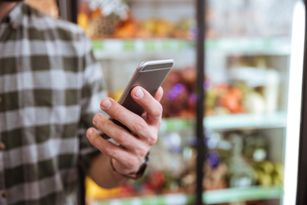 Cell phone used by man in grocery shop